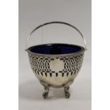 A HALLMARKED SILVER SWING HANDLED BON BON DISH - BIRMINGHAM 1903, with original blue glass liner,