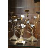 A SET OF THREE GILT METAL FLORAL CANDELABRA WITH CERAMIC PETALS