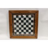 A 19TH CENTURY FOLK ART REVERSE PAINTED GLASS CHESS BOARD, in original oak framed, 60 x 60