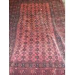 A LARGE EARLY 20TH CENTURY RED AND BLACK WOOLLEN RUG