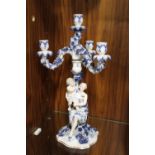 A BLUE AND WHITE DRESDEN STYLE FIGURATIVE CANDELABRA WITH FLORAL DETAIL