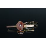 A 9CT GOLD STOCK PIN, set with a polished stone, W 5.5 cm