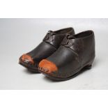 A PAIR OF EARLY 20TH CENTURY CHILDS LEATHER, WOOD AND METAL MOUNTED CLOGS, with embossed metal