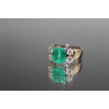 AN 18 CARAT WHITE GOLD EMERALD AND DIAMOND RING, set with a princess cut emerald measuring approx