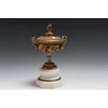 A GILT BRONZE CUP AND COVER, decorated with fruiting vine and a bear finial to the lid, on octagonal