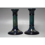 A PAIR OF EARLY 20TH CENTURY WILLIAM MOORCROFT CANDLESTICKS, typical tubeline decoration,