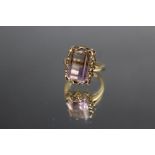 AN UNUSUAL 9K FLOURITE TYPE RING, the central stone being half ink, half yellow in colour and