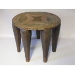 AN EARLY 20TH CENTURY NUPE CARVED WOODEN STOOL, with a chip carved top over seven tapering legs,
