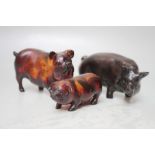 A 20TH CENTURY AMBER STYLE FIGURE MODELLED AS A PIG, L 10.5 cm, together with a similar smaller