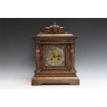 AN EARLY 20TH CENTURY MAHOGANY MANTEL CLOCK, the architectural case with carved mask and