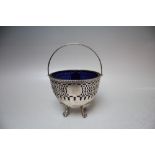 A HALLMARKED SILVER SWING HANDLED BON BON DISH - BIRMINGHAM 1903, with original blue glass liner,
