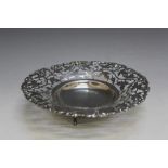A PIERCED WHITE METAL FOOTED DISH, decorated with a fruiting vine design, Dia 17.75 cm