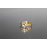 A DIAMOND SOLITAIRE RING, the brilliant cut diamond is rub over set and is of an estimated 1