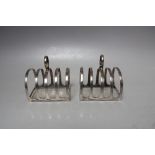 A PAIR OF SMALL HALLMARKED SILVER FOUR SLICE TOAST RACKS - BIRMINGHAM 1931, makers mark for Adie