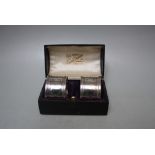 A CASED SET OF TWO HALLMARKED SILVER NAPKIN RINGS - SHEFFIELD 1920, with Fleur-de-lys pattern,