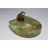 A COLD PAINTED FIGURE OF A DOG SITTING ON AN ONYX TRAY, W 10 cm