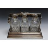 A SILVER PLATED THREE BOTTLE TANTALUS, W 40 cm Condition Report:one bottle has a smoothed out chip