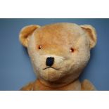 AN EARLY / MID 20TH CENTURY VINTAGE MUSICAL TEDDY BEAR A/F, straw filled, with bells inside tummy,