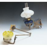 AN ANTIQUE WALL MOUNTED OIL LAMP, with blue glass reservoir, converted for electrical use, W 32