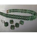 A SINGLE STRAND OF GRADUATED SPINACH JADE BEADS A/F, L 35 cm, together with five shaped panels