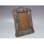 AN EDWARDIAN EASEL BACK PICTURE FRAME, having embossed hallmarked silver border - Birmingham 1904, H