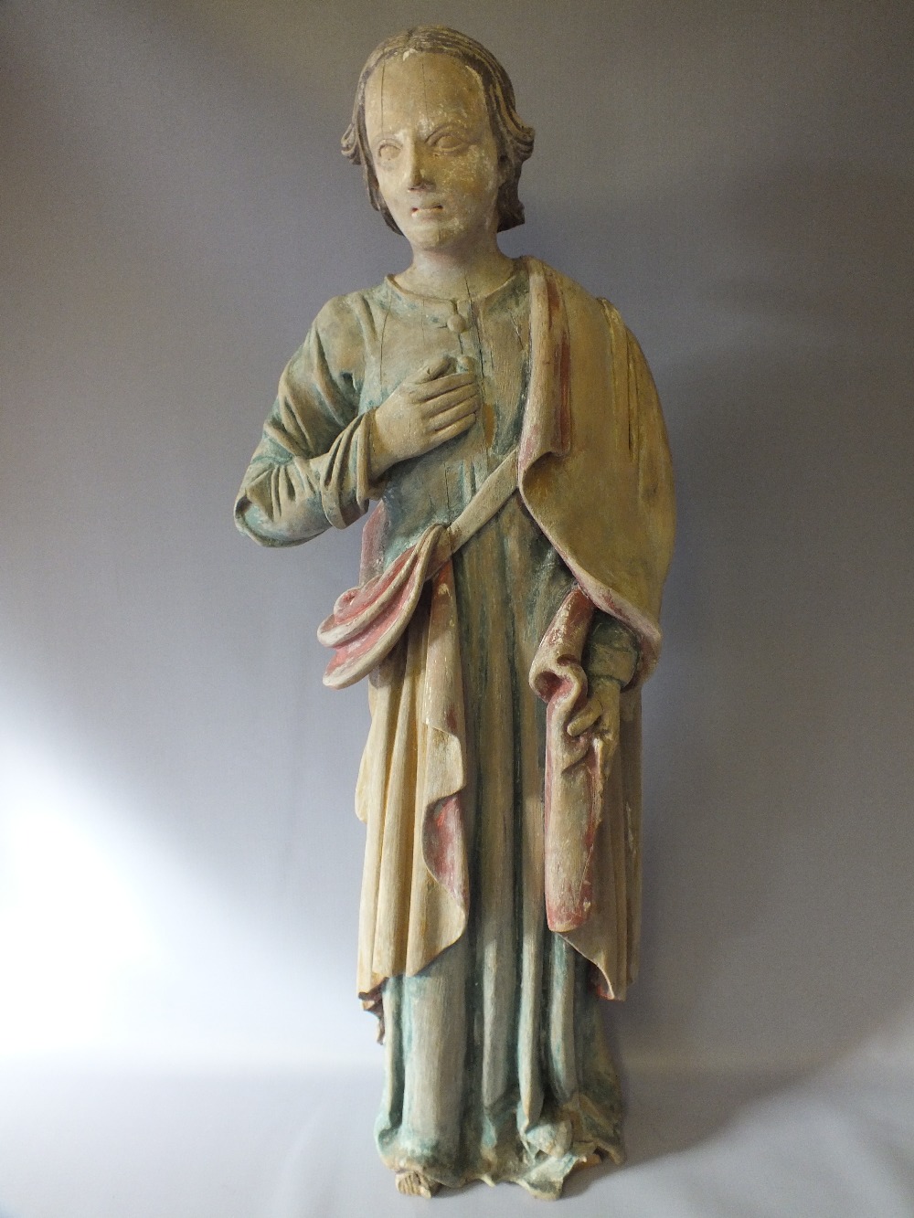 A LARGE EARLY CARVED WOOD RELIGIOUS STATUE DEPICTING A SAINT, with coloured decoration, H 85 cm