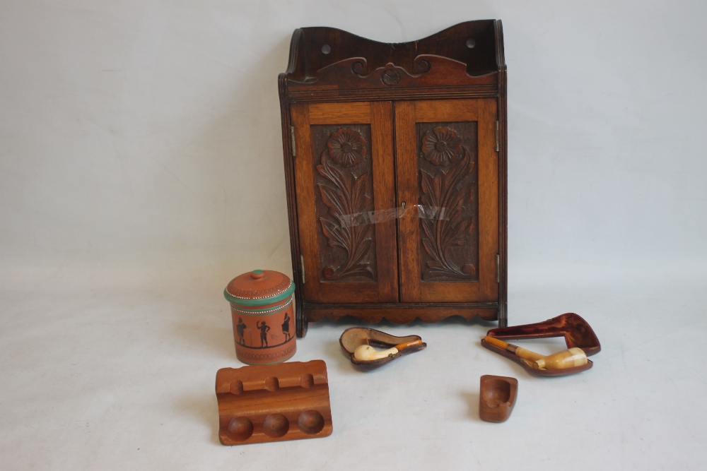 AN EDWARDIAN TWO DOOR SMOKERS' CABINET with terracotta tobacco jar, along with another jar and two