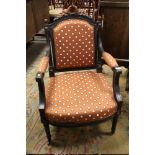 A VINTAGE EBONISED CARVED UPHOLSTERED ARMCHAIR IN THE FRENCH STYLE