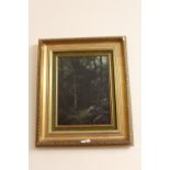 A GILT FRAMED OIL ON CANVAS OF A WOODED LANDSCAPE