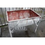 A GALVANIZED TROUGH ON STAND