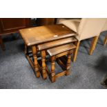 AN OAK NEST OF TABLES TOGETHER WITH A SMALL TEAK CORNER CUPBOARD (2)