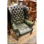 A GREEN LEATHER WINGBACK ARMCHAIR