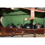 A LEATHER CASED SET OF FOUR CROWN GREEN / LAWN BOWLS