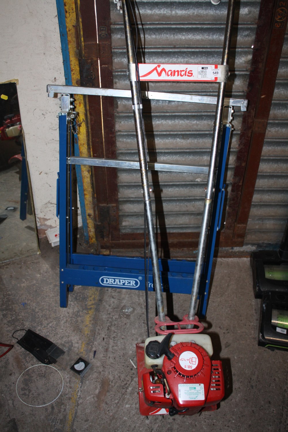 A MANTIS PETROL GARDEN TOOL TOGETHER WITH A DRAPER STAND