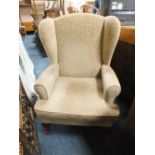 AN UPHOLSTERED WING ARMCHAIR