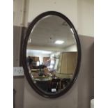 A MAHOGANY OVAL HANGING WALL MIRROR