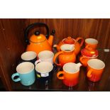 A LE CRUESET ORANGE TWO PERSON TEA SET together with four other Le Crueset mugs and a kettle (11)