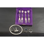 A CASED SET OF FOUR NOVELTY WHITE METAL CARD SUIT TOPPED CHIP FORKS together with a silver bangle,