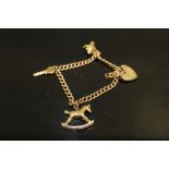 A 9 CARAT ROSE GOLD CHARM BRACELET with yellow gold charms to include a rocking horse shaped example