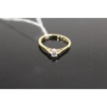 A HALLMARKED 18 CARAT DIAMOND SOLITAIRE RING, the brilliant cut diamond being of an estimated 0.20