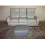 A THREE SEATER VIOLINO LEATHER RECLINING SOFA AND MATCHED POUFFE