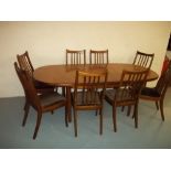 AN EXTENDING TEAK DINING TABLE AND EIGHT CHAIRS