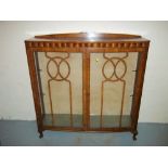 A WALNUT BOWED DISPLAY CABINET