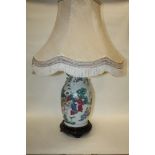 A LARGE CHINESE CERAMIC FIGURATIVE LAMP RAISED ON WOODEN PLINTH WITH SHADE OVERALL HEIGHT - - 93CM