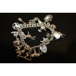 A VINTAGE SILVER CHARM BRACELET WEIGHT - 65.8G APPROX