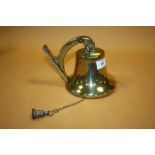 A VINTAGE BRASS WALL MOUNTABLE BELL