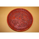 A CHINESE / ORIENTAL CARVED DISH DECORATED WITH A FIVE CLAWED DRAGON AND A PHOENIX DIA - 20.5CM
