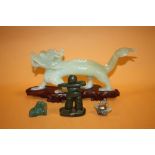 A MODERN ORIENTAL JADE CARVING OF A DRAGON, TOGETHER WITH THREE SMALLER EXAMPLES (DRAGON LENGTH- -