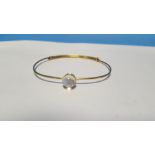 AN UNMARKED YELLOW METAL BANGLE SET WITH A MOONSTONE. Approx weight 6.5 g