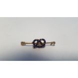 A DIAMOND AND ENAMEL STAFFORDSHIRE KNOT BROOCH. Approx. weight 1.7 g, width 3 cm